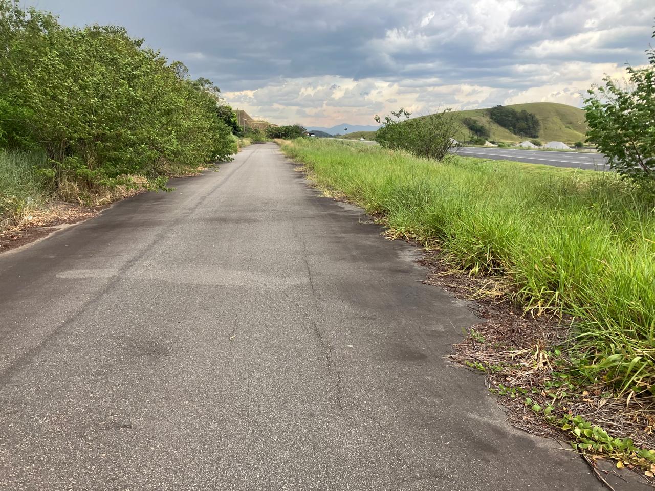 Via asfaltada em frente ao terreno, com a rodovia do Arco Metropolitano ao lado